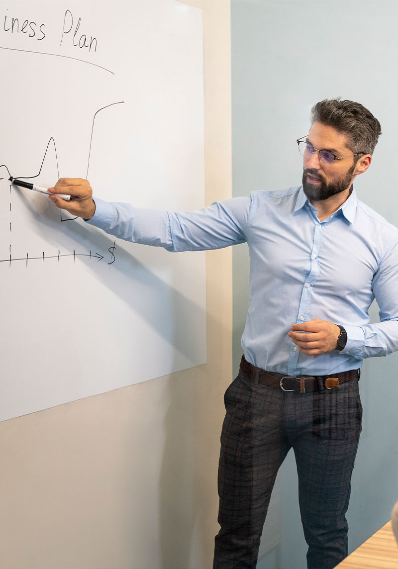 A corporate meeting room with a whiteboard roll, filled with diagrams and brainstorming notes from a team meeting